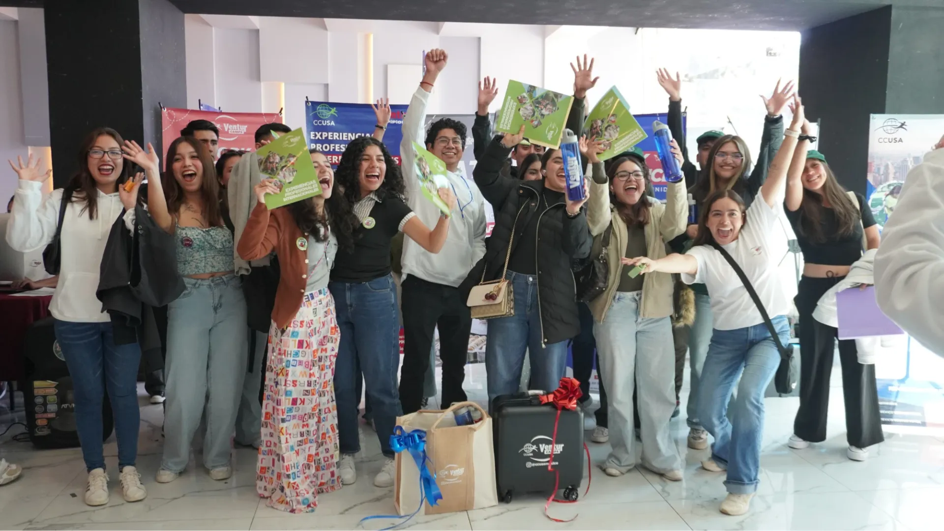 Participantes celebrando con sus folletos en una feria de contratación de Ventur Camps