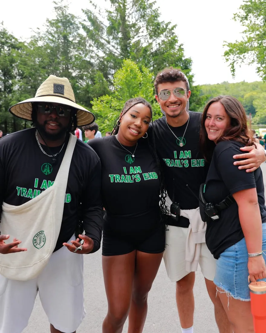 Grupo diverso de participantes abrazados en el campamento